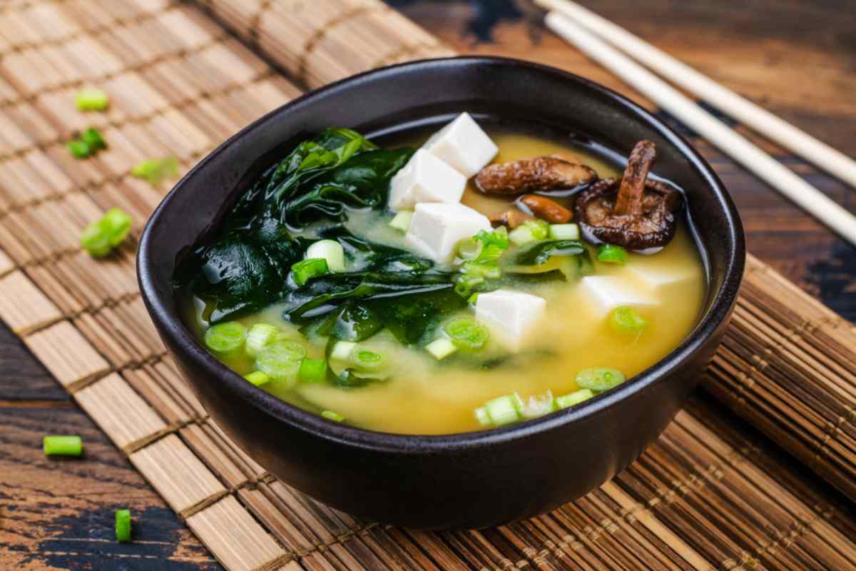 Ciotola di zuppa di miso con tofu, alghe e cipollotto pronta da gustare.